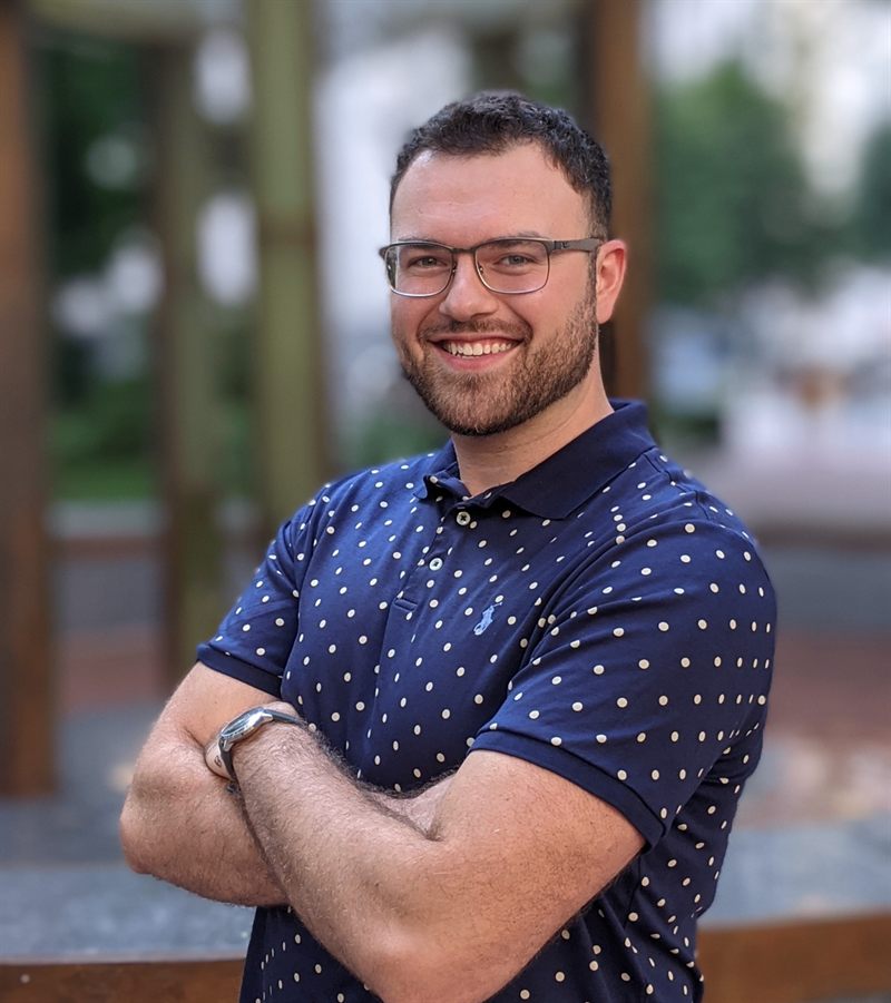 Dan Rosenbaum, smiling with arms crossed